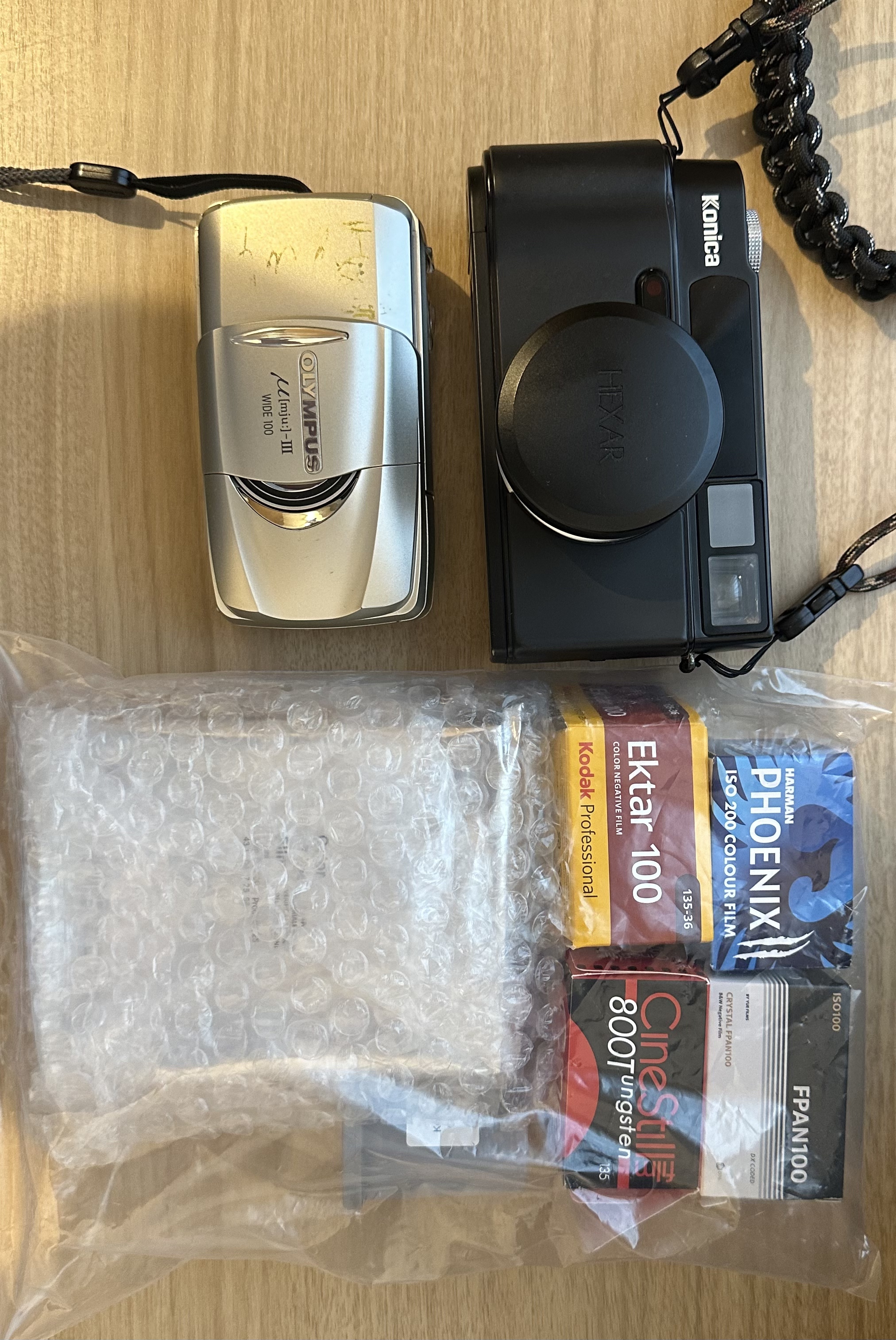 桌面上的两台相机与胶卷盒